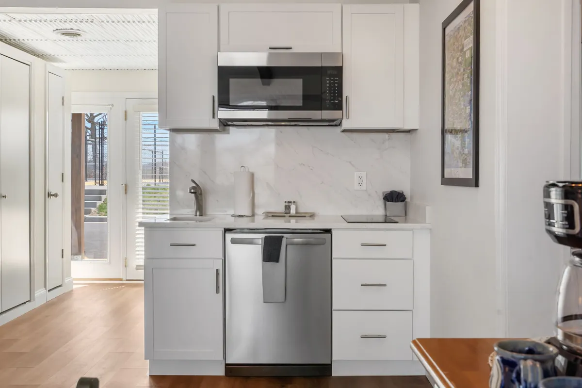 A sleek kitchen scene with stainless steel appliances, a marble backsplash, and modern cabinetry. The space exudes functionality and style, ideal for both casual snacks and more elaborate cooking sessions.